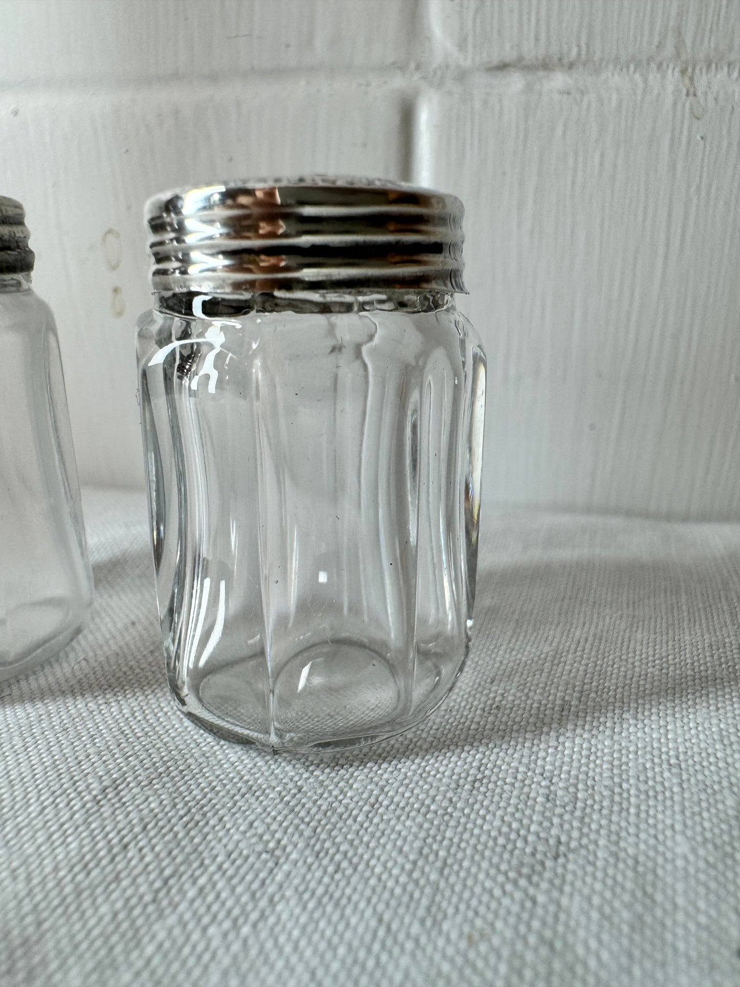 Pair of antique/vintage sterling silver topped salt and pepper pots with faceted glass