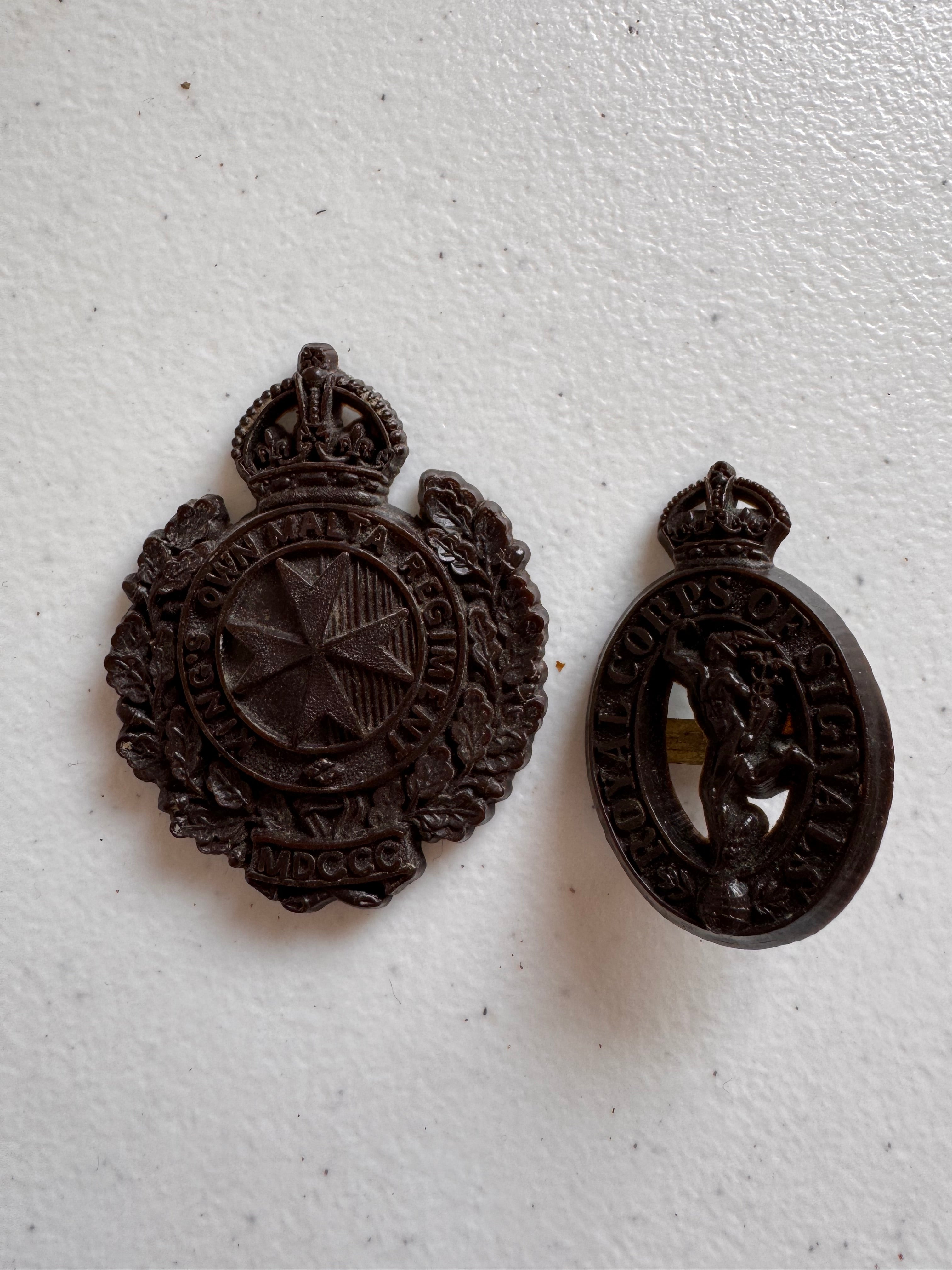 Lot 43: A rare Second World War period King's Own Malta Regiment economy plastic cap badge + other (Estimate £100-200)